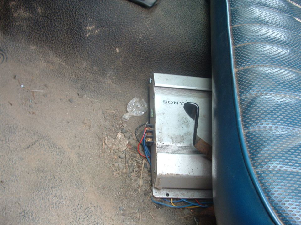 Sony car amplifier with wires connected, mounted on floor under a seat