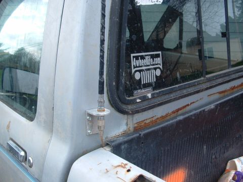 1983 Ford Ranger - Close-up of a truck's side panel, showing an antenna and a sticker on the window.