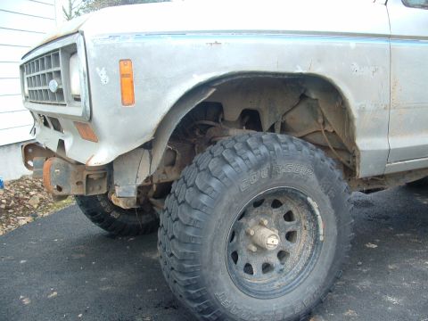 1983 Ford Ranger - Close-up of the front driver's side of a 1983 Ford Ranger, showing the fender, wheel, and grille.