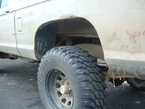 1983 Ford Ranger - This lifted truck features aggressive off-road tires and shows signs of off-road use with mud and rust on the body.