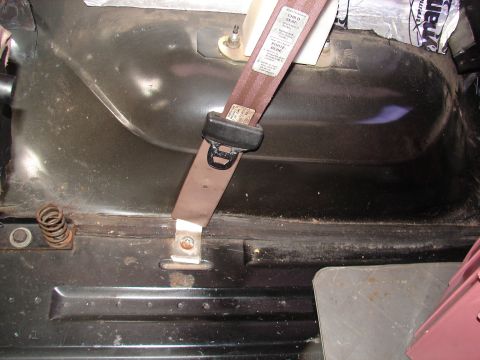 1996 Ford Bronco - Close-up view of a seatbelt mechanism and surrounding interior paneling.