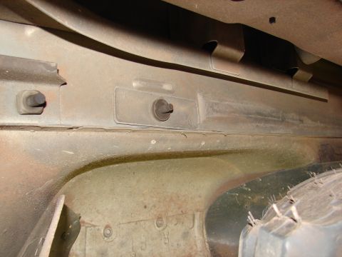 1996 Ford Bronco - Close-up view of the undercarriage of a vehicle, showing structural components and a tire.