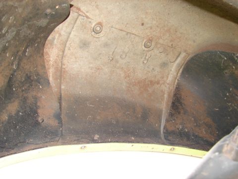 1996 Ford Bronco - This photo shows a close-up of a rusty metal part with some stamped numbers, possibly from the inner fender of a vehicle.