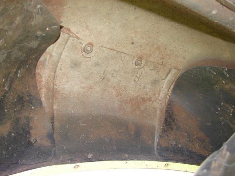 1996 Ford Bronco - Close-up of a rusty inner fender with stamped markings.