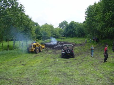 1992 Ford Bronco - Off-road vehicles and a loader are present at an outdoor event.