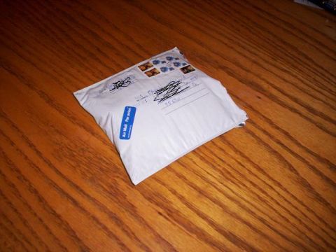 1989 Ford Bronco - A white envelope with postage stamps and handwritten addresses sits on a wooden table.