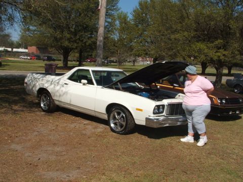 1966 Ford Ranchero - A white pickup truck is parked outdoors with its hood open, next to a woman.