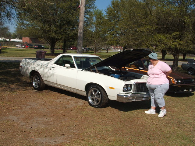 White pickup truck with hood open, chrome bumper, and aftermarket wheels