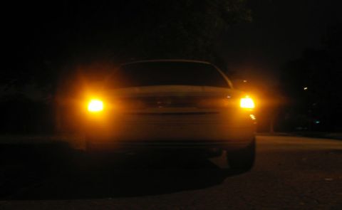 1997 Ford Crown Victoria - A 1997 Ford Crown Victoria is viewed from the front at night with its headlights and turn signals on.