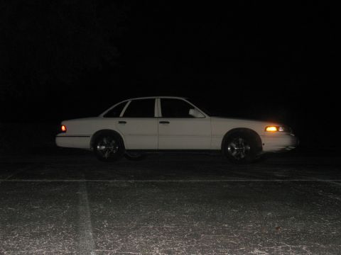 1997 Ford Crown Victoria - Side profile of a white 1997 Ford Crown Victoria sedan captured at night.