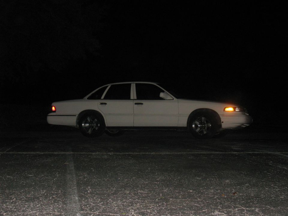 White 1997 Ford Crown Victoria sedan, side view, at night