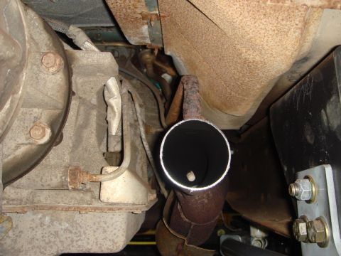 1996 Ford Bronco - Close-up view of the exhaust pipe and transmission assembly from underneath a vehicle.