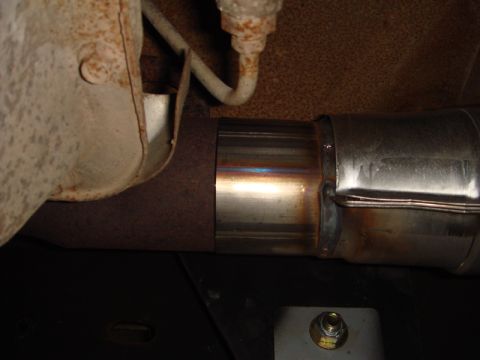 1996 Ford Bronco - Close-up view of a vehicle's exhaust system, highlighting a recent repair with a welded section.
