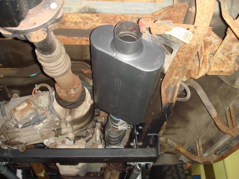 1996 Ford Bronco - The underside of a vehicle displays a newly installed exhaust muffler and associated components.