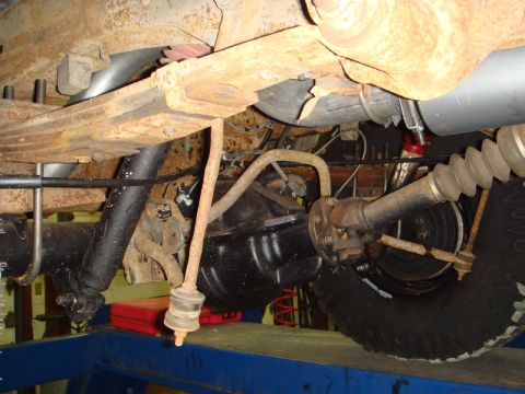 1996 Ford Bronco - Underside view of a 1996 Ford Bronco's rear axle and suspension system, showing significant rust.