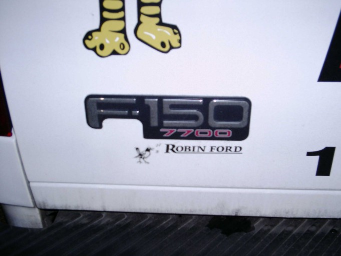Close-up of a Ford F-150 7700 badge with Robin Ford text below it