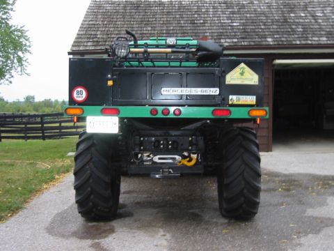 1991 Ford Bronco - This heavily modified truck features oversized tires and a custom rear setup, including a Mercedes-Benz emblem and roof-mounted equipment.