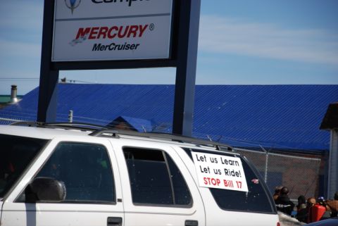1996 Ford Bronco - A white SUV is parked in front of a building with a blue roof and a Mercury sign.