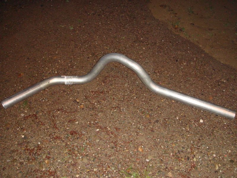 Exhaust pipe with a label on it, lying on the ground