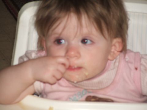 1966 Ford Ranchero - A baby sits in a high chair, looking to the side with food around its mouth.