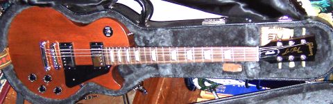 1978 Ford Bronco - A brown electric guitar, identified as a Les Paul model, rests inside its protective case.