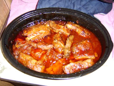 1989 Ford Bronco - A slow cooker filled with ribs in a rich, red sauce sits on a counter.