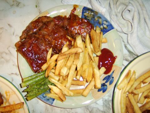 1989 Ford Bronco - A plate of ribs and fries sits on a table next to another plate of fries.