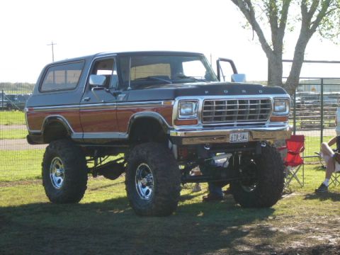1978 Ford Bronco - A lifted 1978 Ford Bronco with a two-tone paint job sits on a grassy field.
