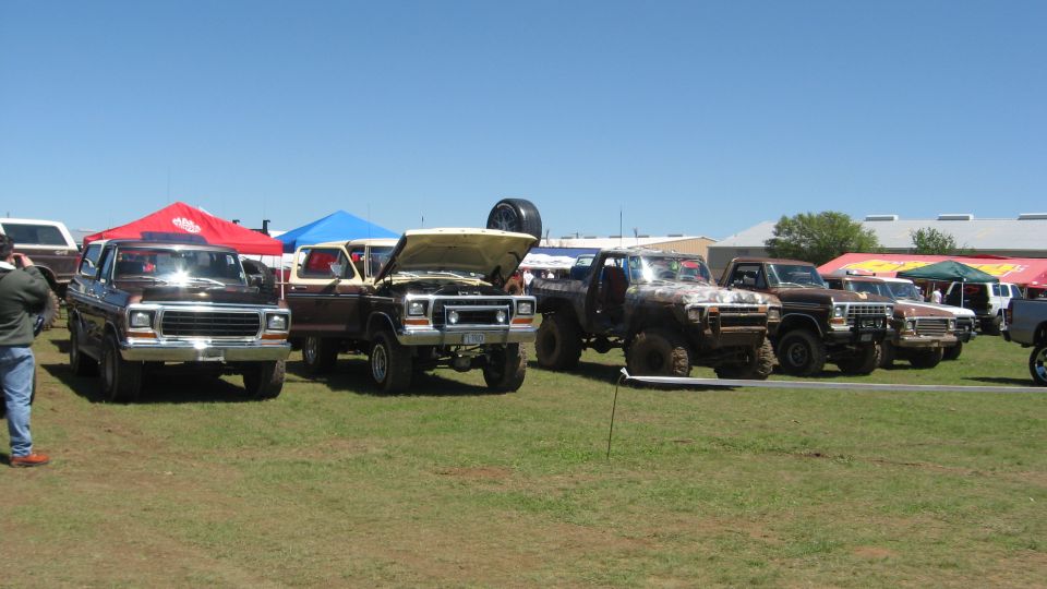 Brown 1978 Ford Bronco parked under a red tent, front view