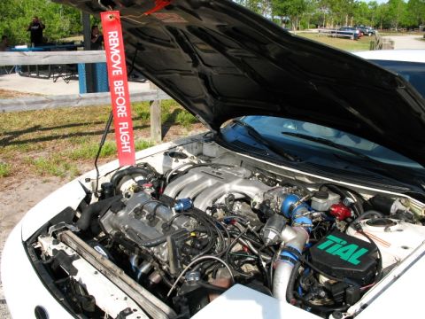 2006 Mazda 6 - The engine bay of a white car is open, revealing aftermarket modifications including a turbocharger and Tial branded components.