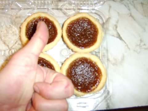 1989 Ford Bronco - Thumb touching a jam tart in a plastic container.