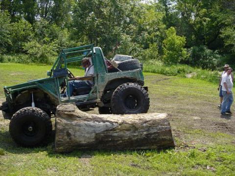 1992 Ford Bronco - A modified off-road vehicle sits in a grassy area, with people standing in the background.