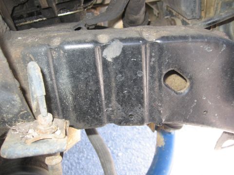 1974 Ford F-100 - Close-up view of a vehicle's frame, showing a metal component with a hole and attached hardware.