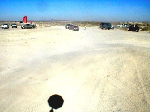 1996 Ford Bronco - A group of vehicles are gathered in a desert area, with a red flag marking a spot.