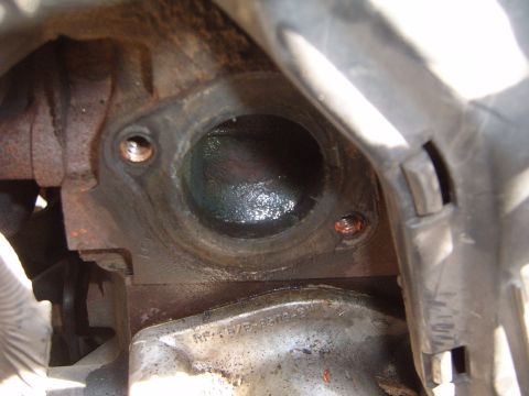 1997 Ford Ranger - Engine block coolant passage opening with visible mounting holes and some residue.