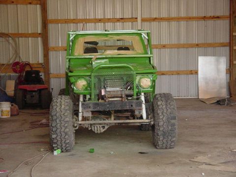1992 Ford Bronco - Off-road vehicle with custom modifications and large tires is parked inside a barn.