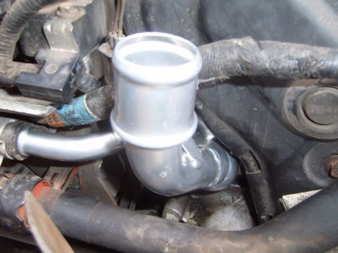 1997 Ford Ranger - This image shows a metal pipe connected to hoses and wiring within a vehicle's engine compartment.