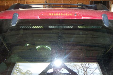 2005 Ford Explorer - Rear view of a 2005 Ford Explorer, showing the window, roof rack, and brake light.