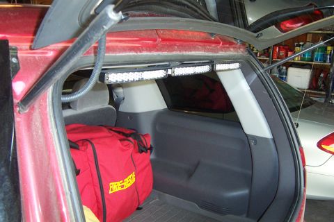 2005 Ford Explorer - The interior of a red 2005 Ford Explorer shows a red fire rescue bag and auxiliary LED light bars.