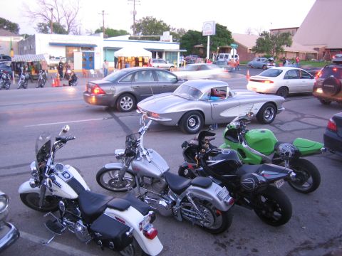 1996 Ford Bronco - Several motorcycles and a vintage silver car are parked together on a street.