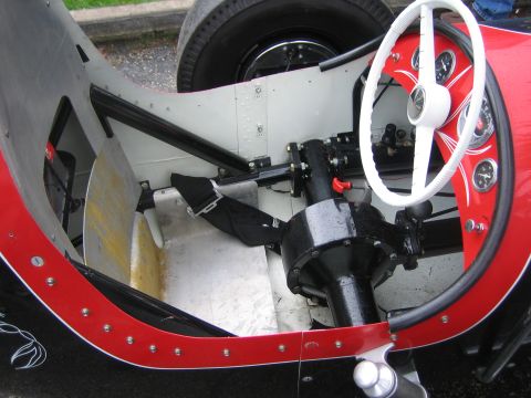 1996 Ford Bronco - Interior view of a vintage race car, showing the steering wheel, gauges, and exposed metal components.