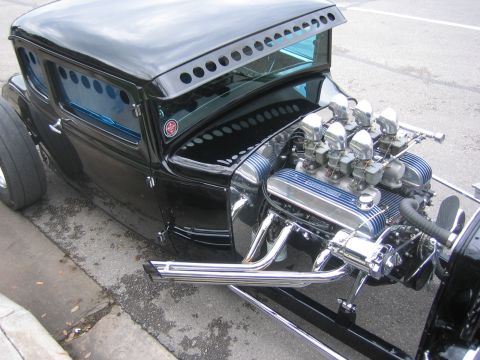 1996 Ford Bronco - A custom hot rod coupe with a powerful V8 engine and a distinctive perforated sun visor is parked on the street.