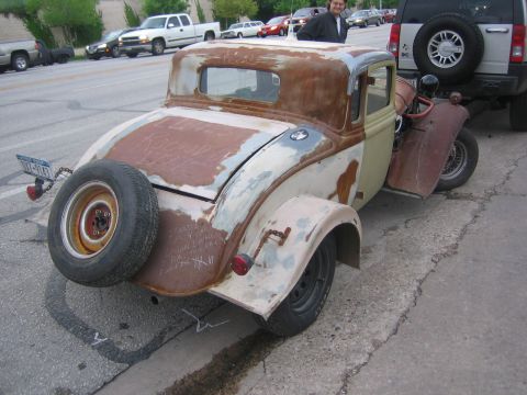 1996 Ford Bronco - This heavily rusted coupe has a spare tire mounted on the back and some writing on the body panels.