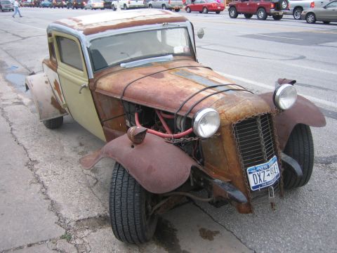 1996 Ford Bronco - A heavily rusted hot rod with a custom grille and exposed engine sits on the side of the road, displaying a New York license plate.