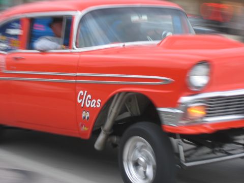 1996 Ford Bronco - A vintage drag car with a prominent hood scoop and custom decals is captured in motion.