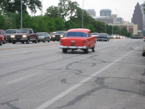1996 Ford Bronco - A red classic car is seen driving on a highway with other vehicles in traffic.