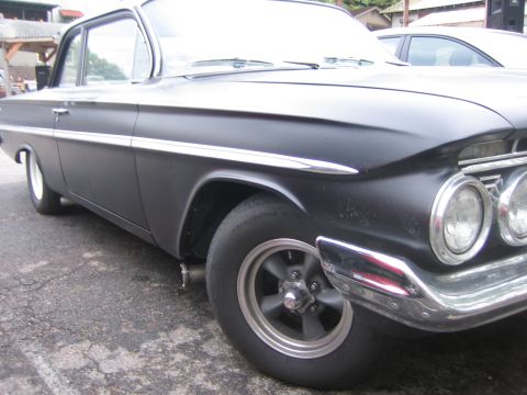 1996 Ford Bronco - Matte black 1960 Chevrolet Impala with chrome accents and custom wheels parked outdoors.