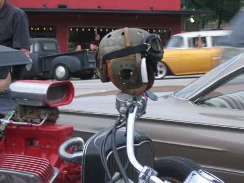 1996 Ford Bronco - A vintage helmet is mounted on the handlebars of a custom vehicle with a prominent red engine intake.