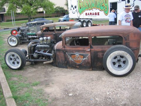 1996 Ford Bronco - A row of custom hot rods, including one with a prominent "Newstalgia Wheels" logo, are parked outdoors.