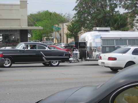 1996 Ford Bronco - A vintage black car is seen towing a polished Airstream trailer on a street with other vehicles.